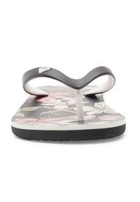 Svart flip-flop med ett V-format rem, vit tång och ett färgglatt blommönster på sulan. Strukturerad svart gummiyttersula.
