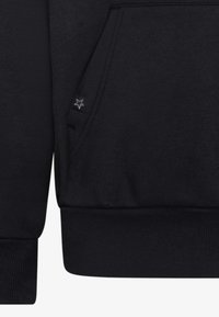 Fekete pulóver kenguru zsebbel, bordázott mandzsettákkal és szegéllyel, valamint egy kis logót tartalmazó címkével az alsó oldalszélen. Sima anyagtextúra.