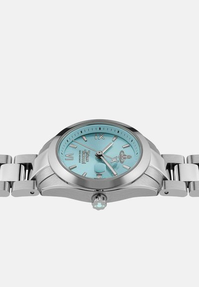 Montre en métal argenté avec un cadran bleu clair, dotée d'index en argent, d'une couronne et d'un bracelet maillon. Design robuste avec finition polie.