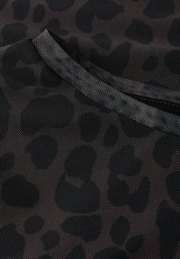 Černá síťovina s leopardím potiskem, s kulatým výstřihem a texturovaným povrchem. Design zdůrazňuje prodyšnost.