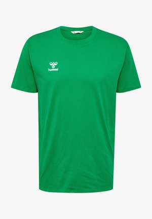 T-shirt en coton vert avec un col rond, des manches courtes et un logo "hummel" blanc contrastant sur la poitrine gauche. Texture lisse, coupe décontractée.