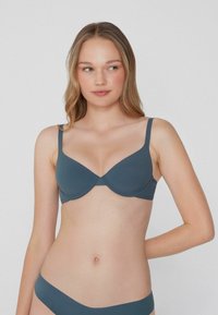 Szary biustonosz z wyściełaniem, z regulowanymi ramiączkami, bezszwowy design i gładka tekstura, w komplecie z pasującymi majtkami bikini.