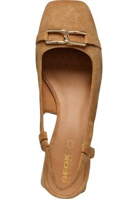 Scarpa piatta in suede beige con punta quadrata, lati a taglio e dettaglio in catena dorata. Presenta una soletta imbottita e un interno testurizzato.