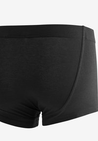 Schwarze Boxershorts mit glatter Textur, elastischem Bund und einer körpernahen Passform, die dank nahtlosem Rücken hohen Komfort und Unterstützung bieten.