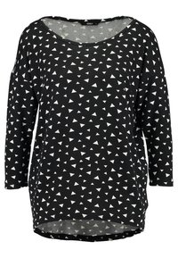 Haut en tissu noir à coupe ample, avec un large décolleté et des manches trois-quarts, orné d'un motif triangulaire blanc sur toute la surface.