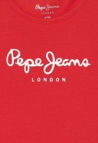 Rød bomulds T-shirt med "Pepe Jeans" i hvid kursiv tekst og "LONDON" i en mindre skrifttype nedenunder, rund halsåbning, glat tekstur.