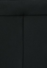 Czarna tkanina z fakturowaną powierzchnią, z szwem na środku i gładkim, płaskim pasem w górnej części.