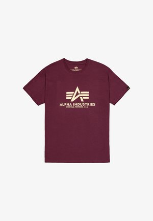 Burgundi környakú póló pamutból, texturált felülettel. Elől nagy fehér "Alpha Industries" logó és embléma található.