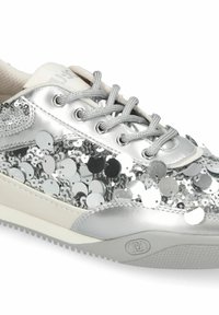 Baskets argentées avec des lacets métalliques et de grands sequins réfléchissants couvrant les côtés et l'avant de la chaussure.