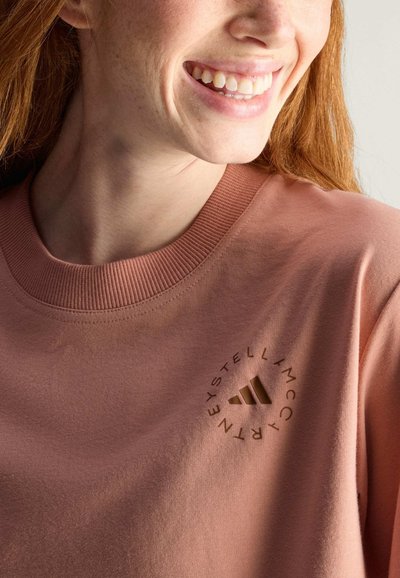 Felpa di cotone rosa con scollatura a girocollo, costine testurizzati e dettaglio rotondo del logo marrone con tre strisce sul petto.