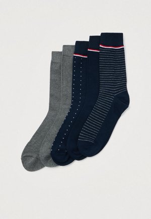Cinque paia di calze da lavoro in grigio e blu navy, caratterizzati da motivi solidi, a pois e a righe con accenti rossi e bianchi sui polsini.