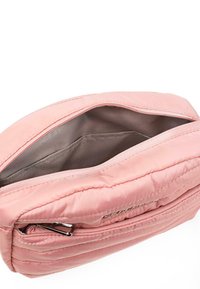 Bolsa acolchada rosa con cierre de cremallera y un bolsillo interior. Textura suave y diseño elegante, que resalta los sutiles detalles de costura.