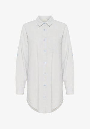 Jasnoniebieska i biała, w paski, koszula z długim rękawem. Posiada kołnierzyk na guziki, jedną kieszeń na piersi oraz zaokrąglony dół. Wykonana z bawełnianego materiału.