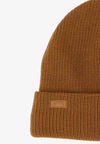 Beanie marrone a maglia con un motivo a coste texturizzato e un risvolto, dotato di una piccola etichetta in pelle color cuoio.