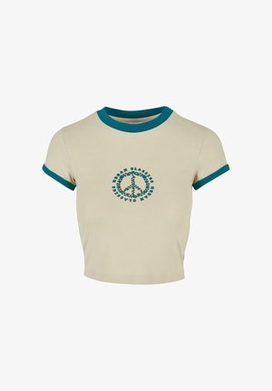 Kermavaalean lyhythihainen crop-top, jossa on tealväriset ribbikohokohdat ja kukkakuvioinen rauhanmerkki keskiössä edessä.