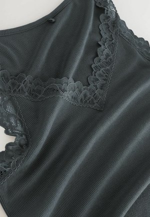 Tamsiai pilkas įpjovos tank top'as, kuriame yra subtilus nėrinių apdangalas kakle ir rankovių vietose, sukuriantis tekstūruotą ir sluoksniuotą išvaizdą.