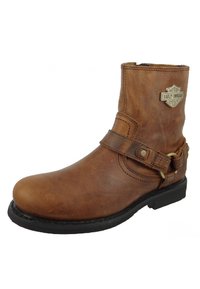 Bruine leren enkelboot met een ronde neus, zijband en gespdetail, rubberen zool en Harley-Davidson logo. Matte textuur.