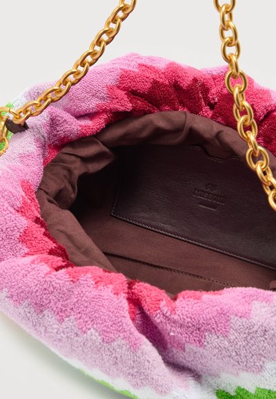 Sac à main avec extérieur en tissu texturé rose et rouge, anses en chaîne dorée, et doublure intérieure marron foncé avec une petite poche.