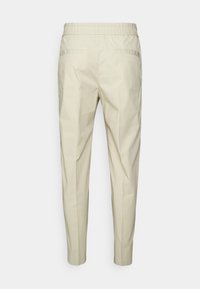 Světlé béžové taper kalhoty s elastickým pasem, dvěma zadními kapsami a hladkým, mírně strukturovaným materiálem.