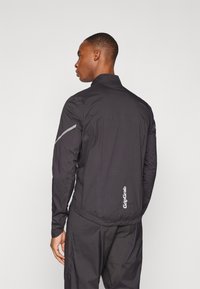 Schwarze leichte Jacke mit hohem Kragen, elastischem Saum und reflektierenden Akzenten. Auf der Rückseite befindet sich der Schriftzug "GripGrab".