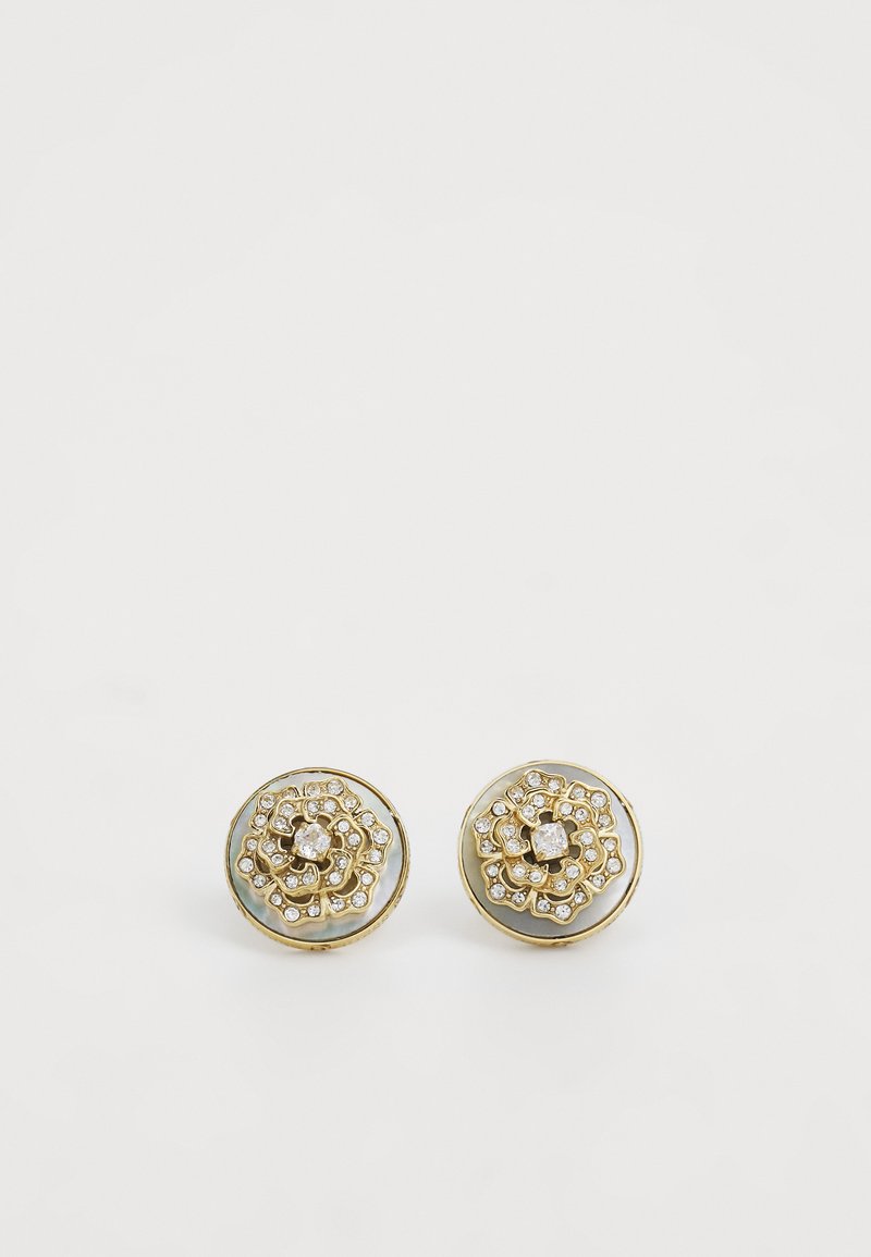 Boucles d'oreilles dorées au design floral, ornées de cristaux transparents et d'une base circulaire lisse avec des accents irisés.