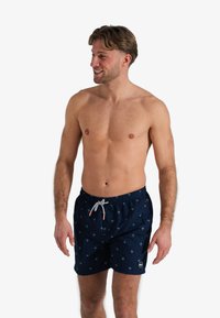 Marine zwemshorts van lichtgewicht stof met een palmbomenpatroon. Elastische tailleband met trekkoord en contrasterende accentdetails.