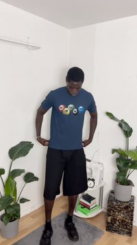 Μπλε μπλουζάκι με πολύχρωμα κυκλικά γραφικά που γράφουν «CRUSH». Συνδυασμένο με μαύρες βερμούδες και μαύρα παπούτσια, σε έναν μινιμαλιστικό φόντο.