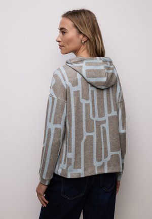 Sweat à capuche beige avec motif géométrique bleu, fabriqué en matériau doux. Caractérisé par une coupe décontractée et des manches longues.