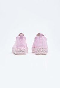 Espadrillas in tela rosa con suola in juta testurizzata. Presenta una linguetta posteriore per un facile indossamento. Parte superiore liscia e dettagli intrecciati attorno alla suola.