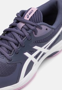 Lilla sportssko med mesh tekstur, hvide detaljer og lyserøde accenter. Har en polstret tunge og snørebånd for en sikker pasform.
