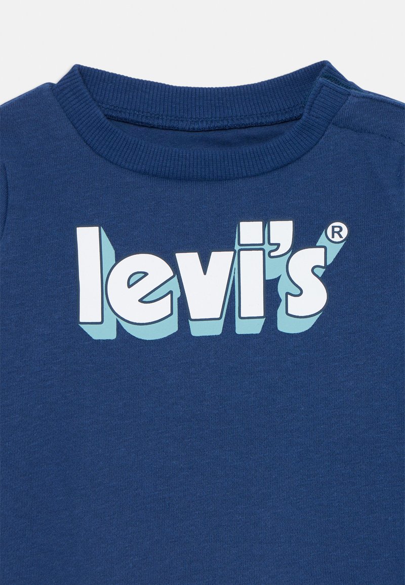 Sweatshirt Levi's bleu avec col rond côtelé et texte en logo blanc audacieux avec une ombre bleu clair sur la poitrine.