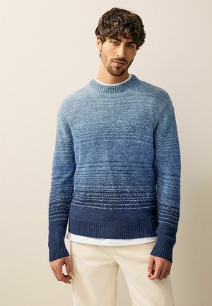 Knit sweater in gradient blue, featuring a ribbed crew neckline and cuffs. Textured, striped pattern with darker hem and sleeves.
