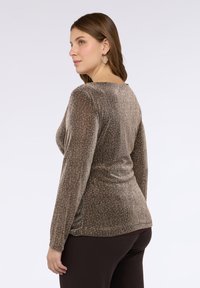 Top z długim rękawem wykonany z metalicznej, brązowej tkaniny o pionowej, prążkowanej fakturze i subtelnym połysku. Posiada zaokrąglony dekolt i dopasowany fason.