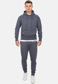 Heren athleisure set: grijze hoodie met trekkoorden en voorzak, gecombineerd met bijpassende joggers met elastische boorden en merkborduring.