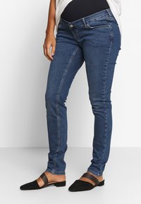 Smal passform blå jeans i denim, med knäppning, framfickor och en slät yta med minimala synliga sömmar.