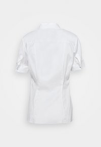 Chemisier blanc à manches courtes avec un col classique, une coupe ajustée et des manches retroussées ornées de boutons, fabriqué en tissu lisse.