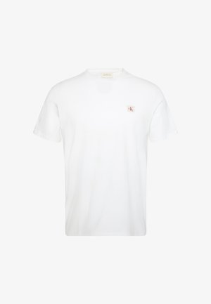 White cotton T-shirt with short sleeves and a round neckline. Features a small, square red and white CK logo on the left chest.