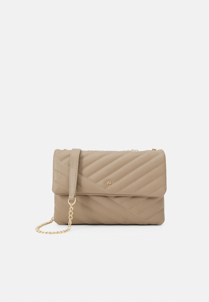 Quilted beige handbag with a flap closure, gold chain strap, and embossed logo. Soft leather texture with diagonal stitching details.