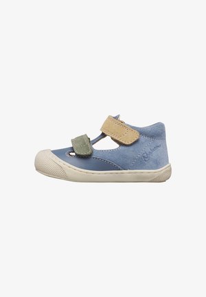 Zapato para niño pequeño en azul y beige con correas de Velcro verdes y beige, suela blanda y contrafuerte de ante en el talón sobre fondo blanco.