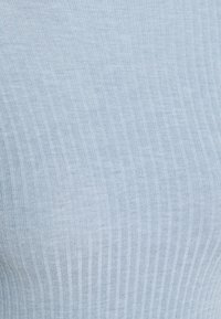 Light blue ribbed fabric with a soft texture, featuring vertical stripes for a snug fit. Material appears stretchy and form-fitting.