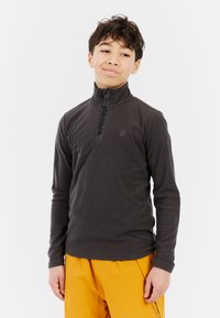 Donkergrijze fleece pullover met een kwart rits en zwart logo op de borst, gecombineerd met feloranje broek. Glad textuur, lange mouwen.