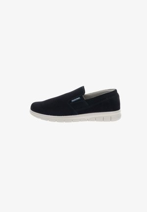 Scarpa casual nera slip-on con suola bianca flessibile e piccola etichetta del marchio sul lato esterno, mostrata su sfondo bianco.