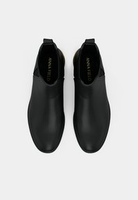 Sorte lær ankle boots med en glat overflade, elastiske sidepaneler og en træksløjfe, med en rund tå og minimalistisk design.