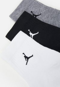 Tri par deodorantnih nogavic v črni, sivi in beli barvi, ki imajo teksturirano blago ter črn logotip Jumpman na vsakih nogavicah.