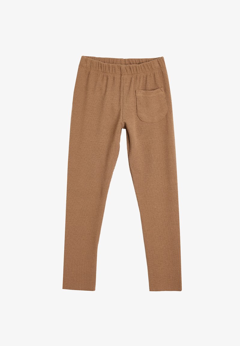 Brązowe legginsy o teksturowanej fakturze, z elastycznym pasem i tylną kieszenią. Materiał ma wzór przypominający wafle.