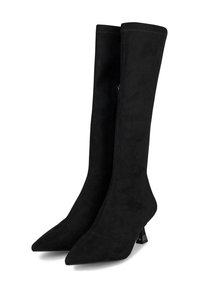 Botas negras de ante hasta la rodilla con puntera afilada, cierre de cremallera y un tacón escultórico. Presentan una textura suave y un diseño minimalista.