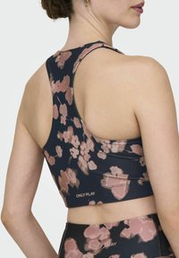 Sportski grudnjak s mornarskom podlogom i ružičastim cvjetnim uzorkom, glatke teksture, širokim naramenicama i logotipom na rubu.