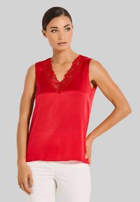 Rotes satinähnliches, ärmelloses Top mit einem V-Ausschnitt, der mit einer floralen Spitze verziert ist. Glatter Stoff, figurbetont und mit geradem Saum.