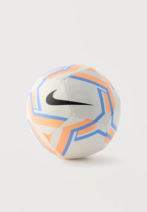 Bijela nogometna lopta s narančastim i plavim geometrijskim uzorcima te crnim Nike Swoosh logom na jednobojnoj svijetloj pozadini.