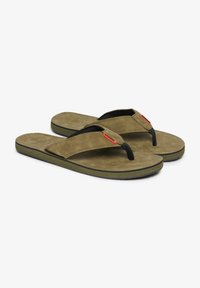 Chanclas verde oliva con correas negras, hechas de material suave. Presentan una plantilla texturizada y un sutil acento rojo en la correa.